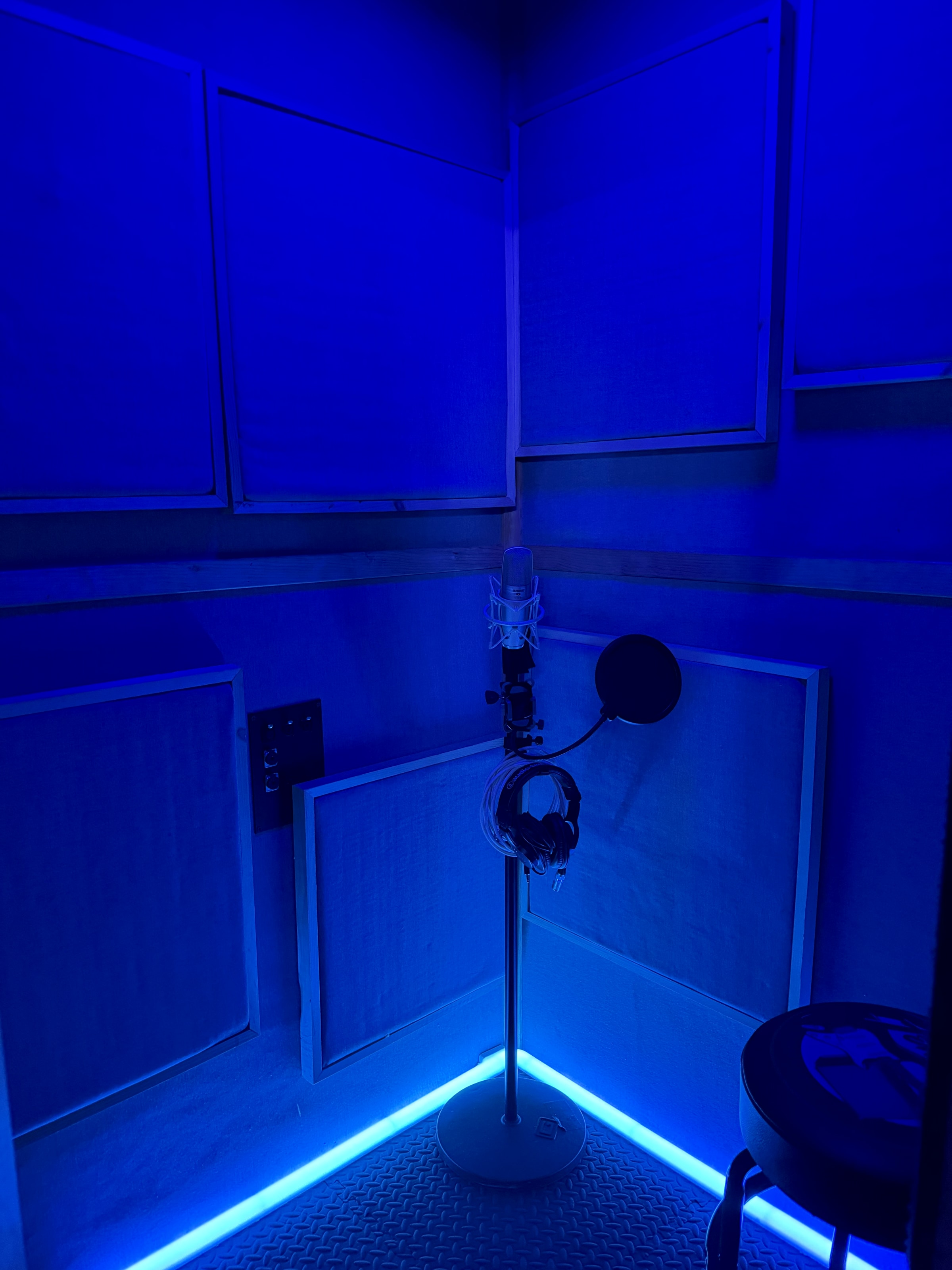Vocal booth with condenser mic, pop filter, and blue LED accent lighting